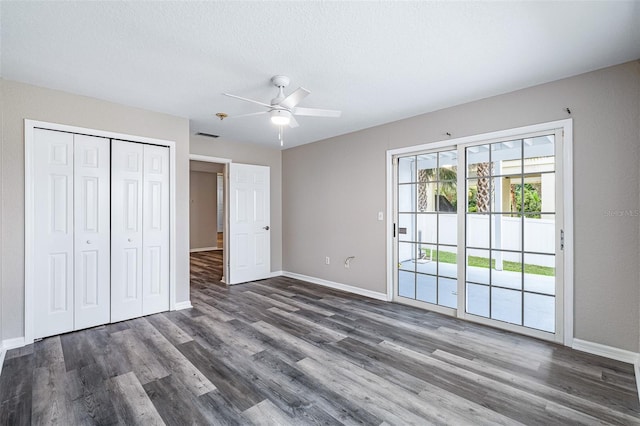 1115 N Central Ave, Flagler Beach, FL 32136 - unfurnished bedroom featuring access to exterior, dark wood finished floors, a closet, a ceiling fan, and a textured ceiling