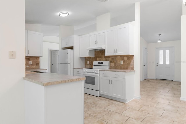 23 Pennfield Ln, Palm Coast, FL 32164 - kitchen with white appliances, under cabinet range hood, decorative backsplash, white cabinetry, and light countertops