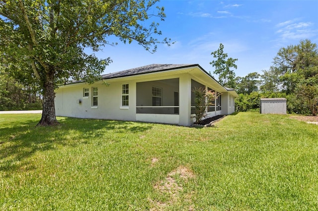 23 Pennfield Ln, Palm Coast, FL 32164 - rear view of property with a storage shed, a yard, stucco siding, and a sunroom