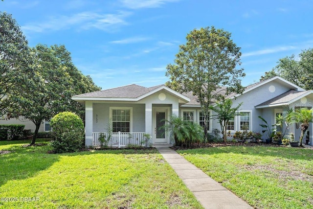 3132 Connemara Dr, Ormond Beach, FL 32174 - view of front of home featuring a porch, stucco siding, a front lawn, and roof with shingles