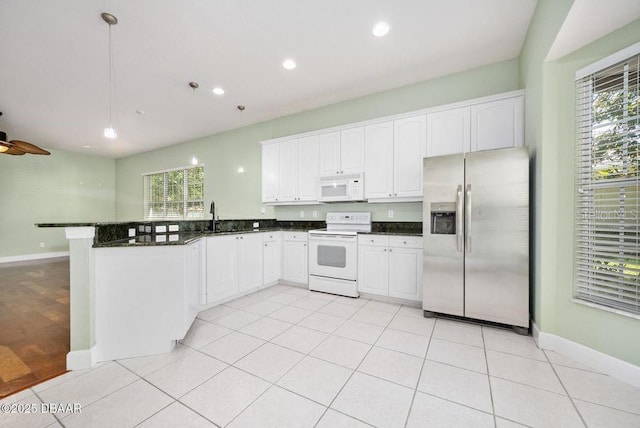 3132 Connemara Dr, Ormond Beach, FL 32174 - kitchen with white appliances, a peninsula, healthy amount of natural light, white cabinetry, and recessed lighting