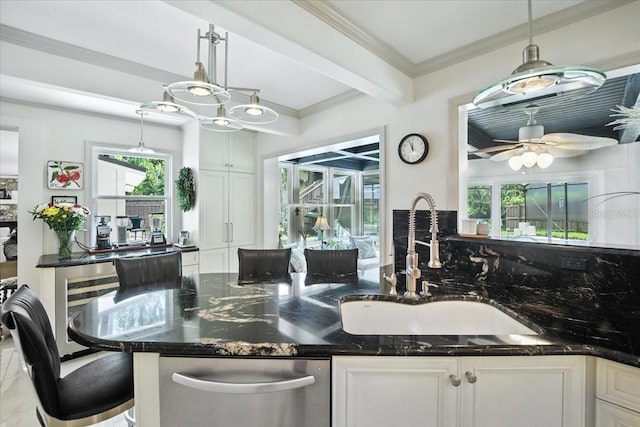 1108 Shockney Dr, Ormond Beach, FL 32174 - kitchen featuring stainless steel dishwasher, white cabinets, dark stone countertops, hanging light fixtures, and crown molding