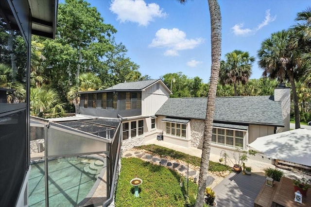 1108 Shockney Dr, Ormond Beach, FL 32174 - rear view of house with roof with shingles, a patio area, a chimney, glass enclosure, and an outdoor pool