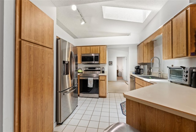 1 Ryberry Pl, Palm Coast, FL 32164 - kitchen with appliances with stainless steel finishes, light tile patterned floors, track lighting, light countertops, and brown cabinetry