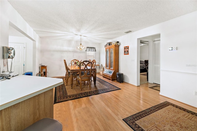 1 Ryberry Pl, Palm Coast, FL 32164 - dining space featuring light wood finished floors, a textured ceiling, and a chandelier