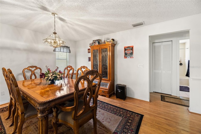 1 Ryberry Pl, Palm Coast, FL 32164 - dining space with a chandelier, light wood-style flooring, and a textured ceiling