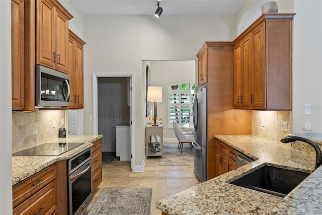 1254 Royal Pointe Ln, Ormond Beach, FL 32174 - kitchen featuring appliances with stainless steel finishes, light stone counters, brown cabinets, and backsplash
