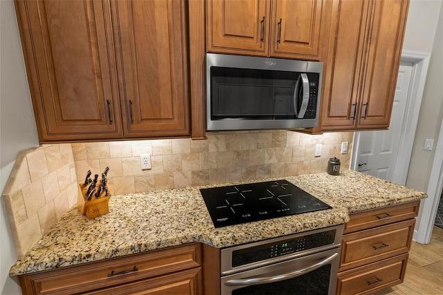 1254 Royal Pointe Ln, Ormond Beach, FL 32174 - kitchen featuring stainless steel appliances, light stone counters, backsplash, and brown cabinetry