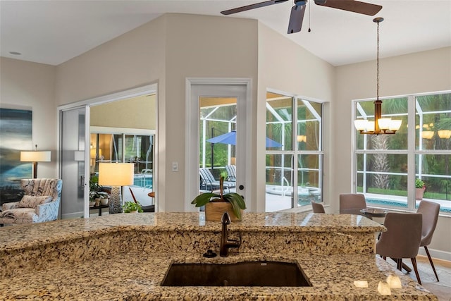 1254 Royal Pointe Ln, Ormond Beach, FL 32174 - kitchen with light stone counters, a ceiling fan, pendant lighting, a chandelier, and open floor plan
