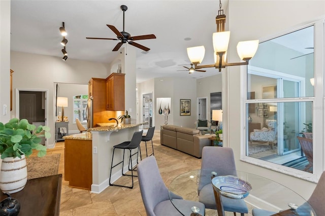 1254 Royal Pointe Ln, Ormond Beach, FL 32174 - kitchen with ceiling fan, brown cabinetry, a peninsula, a breakfast bar, and open floor plan