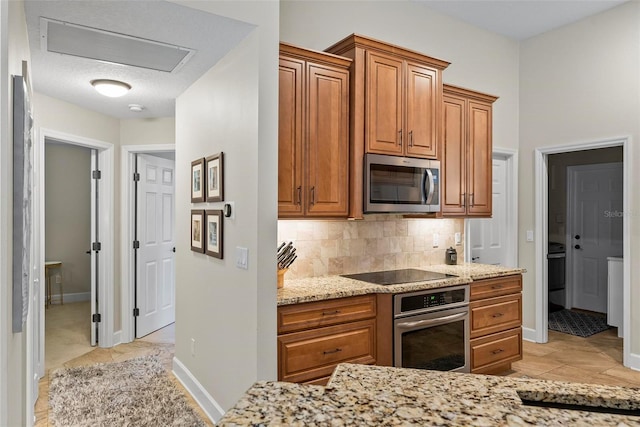 1254 Royal Pointe Ln, Ormond Beach, FL 32174 - kitchen featuring stainless steel appliances, tasteful backsplash, light stone counters, brown cabinets, and light tile patterned floors