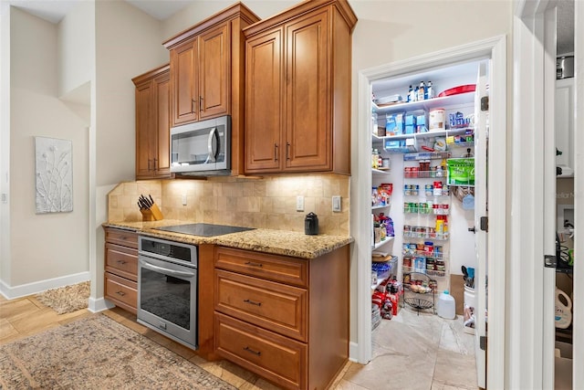 1254 Royal Pointe Ln, Ormond Beach, FL 32174 - kitchen featuring appliances with stainless steel finishes, light stone counters, decorative backsplash, and brown cabinetry