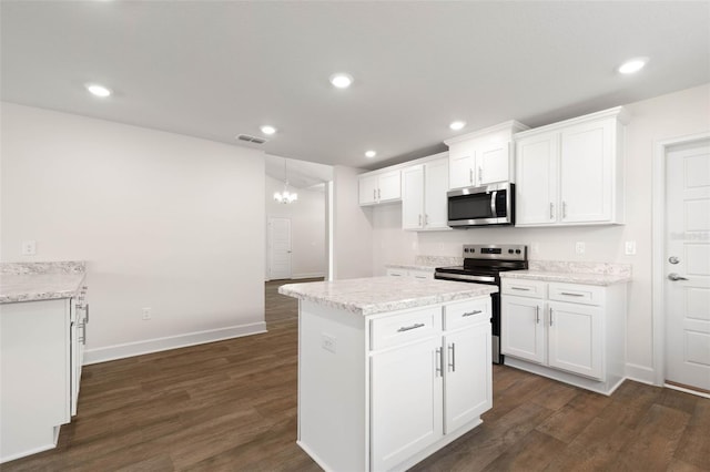 18 Slipper Orchid Trl E, Palm Coast, FL 32164 - kitchen with appliances with stainless steel finishes, dark wood-style floors, white cabinetry, recessed lighting, and light stone counters