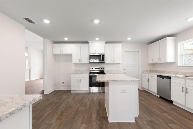 18 Slipper Orchid Trl E, Palm Coast, FL 32164 - kitchen with stainless steel appliances, white cabinets, dark wood-style flooring, a center island, and recessed lighting