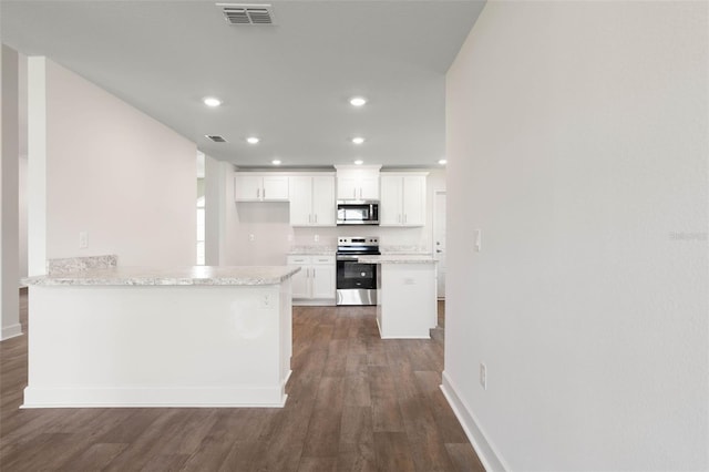 18 Slipper Orchid Trl E, Palm Coast, FL 32164 - kitchen with appliances with stainless steel finishes, dark wood-type flooring, white cabinetry, recessed lighting, and a peninsula