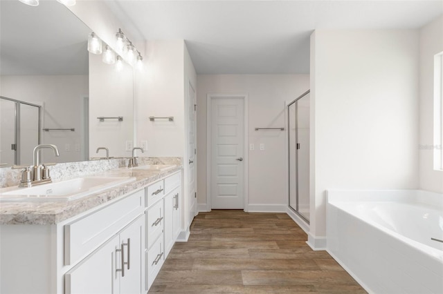 18 Slipper Orchid Trl E, Palm Coast, FL 32164 - full bathroom with double vanity, a shower stall, a garden tub, and wood finished floors