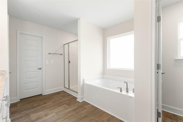 18 Slipper Orchid Trl E, Palm Coast, FL 32164 - bathroom featuring a garden tub, a stall shower, wood finished floors, and vanity