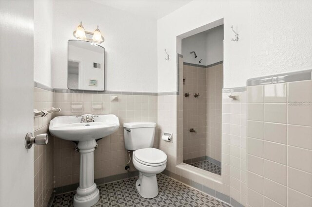 1026 Bel Aire Dr, Daytona Beach, FL 32118 - full bath featuring tile walls, a shower stall, and wainscoting
