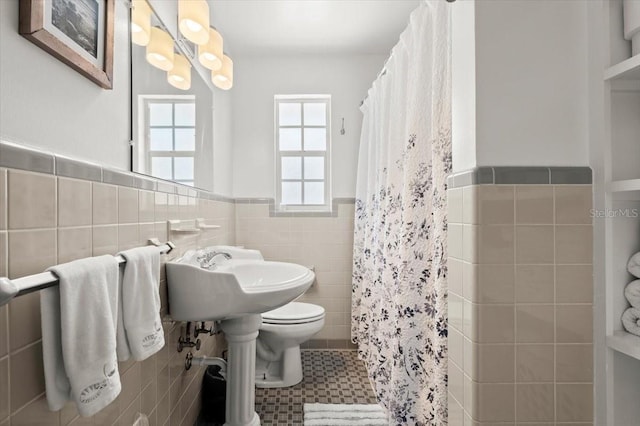 1026 Bel Aire Dr, Daytona Beach, FL 32118 - bathroom featuring tile walls, a wainscoted wall, and a shower with curtain