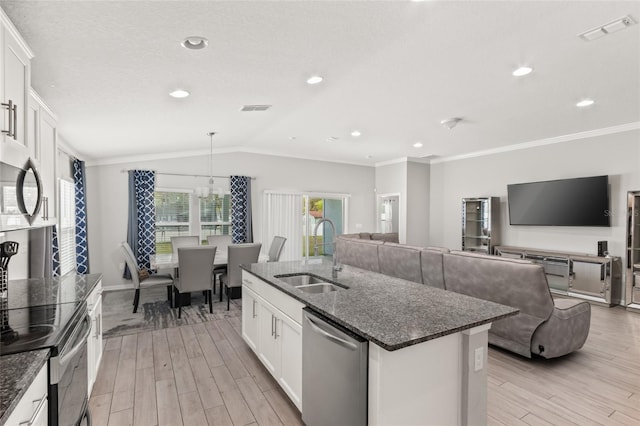 392 S Hamilton Springs Rd, Saint Augustine, FL 32084 - kitchen featuring stainless steel appliances, light wood-style flooring, a center island with sink, white cabinets, and vaulted ceiling