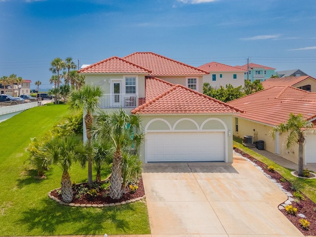 1528 N Daytona Ave, Flagler Beach, FL 32136 - mediterranean / spanish-style home with a balcony, an attached garage, driveway, a tiled roof, and a front lawn