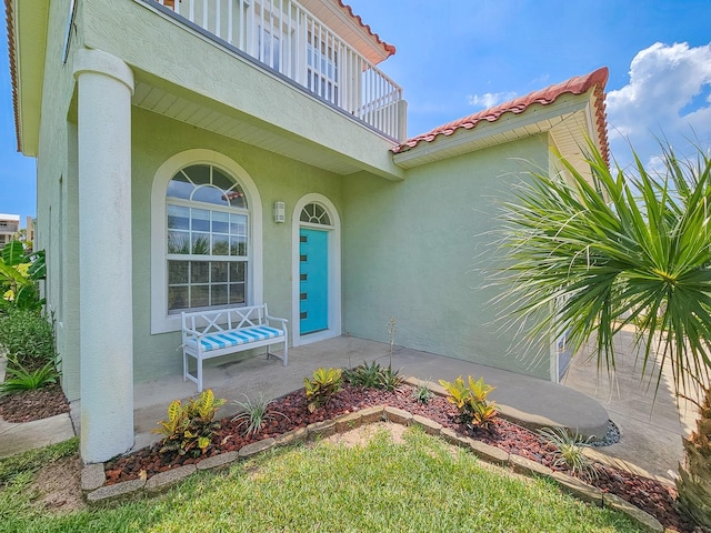 1528 N Daytona Ave, Flagler Beach, FL 32136 - entrance to property featuring stucco siding, a porch, and a tile roof