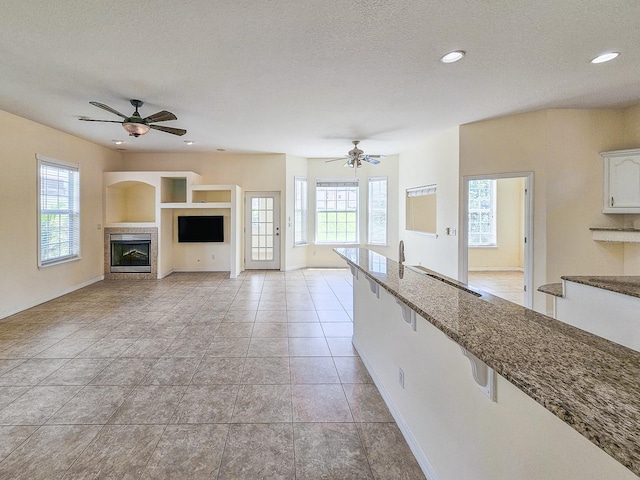 1528 N Daytona Ave, Flagler Beach, FL 32136 - kitchen with a fireplace, healthy amount of natural light, a ceiling fan, a textured ceiling, and recessed lighting