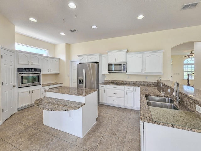 1528 N Daytona Ave, Flagler Beach, FL 32136 - kitchen with stainless steel appliances, white cabinets, recessed lighting, light tile patterned floors, and dark stone countertops