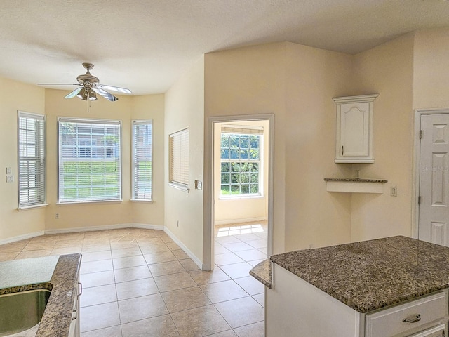 1528 N Daytona Ave, Flagler Beach, FL 32136 - kitchen featuring ceiling fan, white cabinets, and dark stone counters