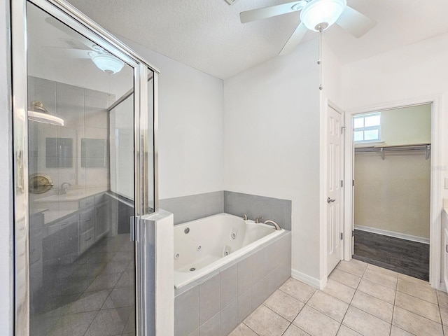 1528 N Daytona Ave, Flagler Beach, FL 32136 - full bath with a shower stall, a tub with jets, a walk in closet, tile patterned floors, and a ceiling fan