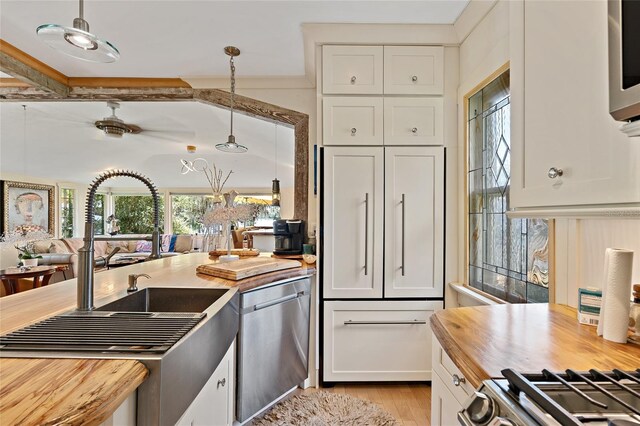 603 Front St, Welaka, FL 32193 - kitchen with dishwasher, butcher block countertops, white cabinetry, light wood-style flooring, and stove