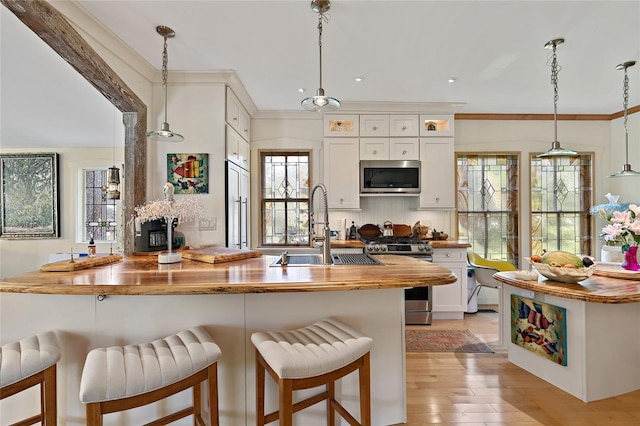 603 Front St, Welaka, FL 32193 - kitchen featuring appliances with stainless steel finishes, butcher block countertops, a kitchen bar, decorative light fixtures, and recessed lighting