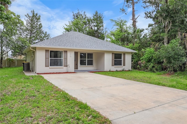 204 S Forsyth St, Bunnell, FL 32110 - view of front facade featuring stucco siding, a front yard, concrete driveway, and a shingled roof