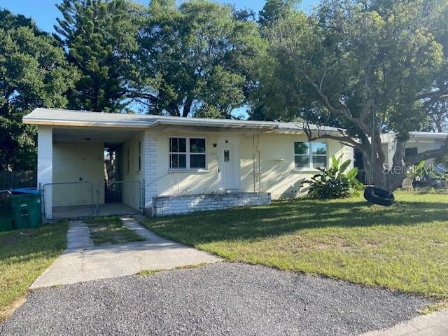 264 Sherwood Ln, Daytona Beach, FL 32117 - view of front facade featuring driveway, a front lawn, and an attached carport