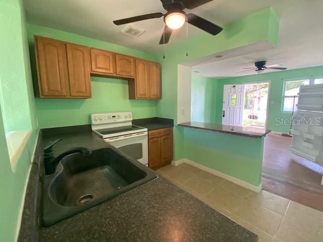 264 Sherwood Ln, Daytona Beach, FL 32117 - kitchen with electric range, a ceiling fan, dark countertops, and a peninsula