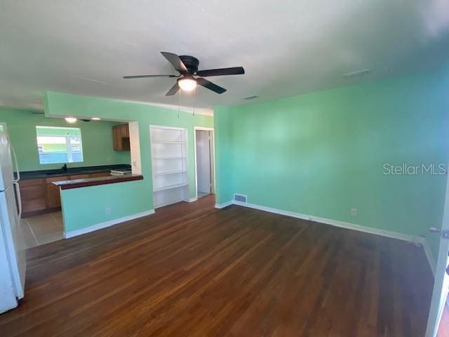 264 Sherwood Ln, Daytona Beach, FL 32117 - unfurnished living room featuring wood finished floors, a ceiling fan, and built in shelves