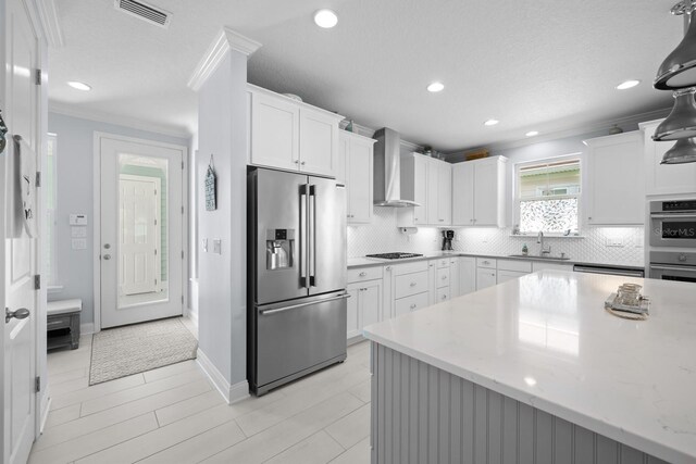 31 Hidden Treasure Dr, Palm Coast, FL 32137 - kitchen featuring appliances with stainless steel finishes, wall chimney range hood, decorative backsplash, recessed lighting, and ornamental molding