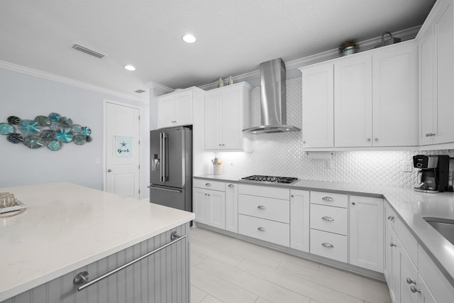31 Hidden Treasure Dr, Palm Coast, FL 32137 - kitchen with appliances with stainless steel finishes, wall chimney exhaust hood, ornamental molding, tasteful backsplash, and white cabinets