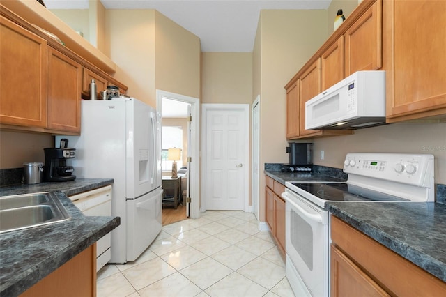 6 Prince Michael Ln, Palm Coast, FL 32164 - kitchen featuring white appliances, dark countertops, brown cabinets, and light tile patterned floors
