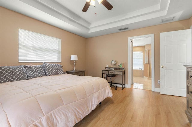 6 Prince Michael Ln, Palm Coast, FL 32164 - bedroom with a raised ceiling, light wood finished floors, ceiling fan, and ensuite bath