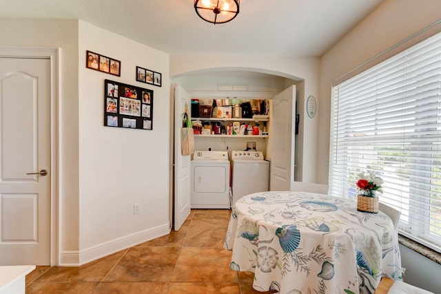 146 Palm Coast Resort Blvd Unit 501, Palm Coast, FL 32137 - dining space featuring separate washer and dryer, arched walkways, and light tile patterned floors