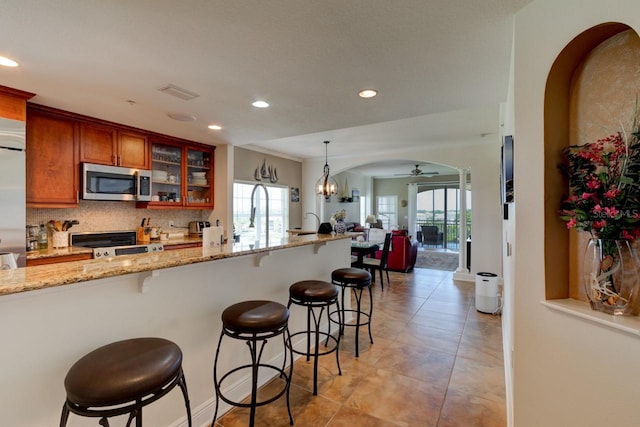 146 Palm Coast Resort Blvd Unit 501, Palm Coast, FL 32137 - kitchen featuring stainless steel microwave, recessed lighting, stove, ceiling fan, and brown cabinetry