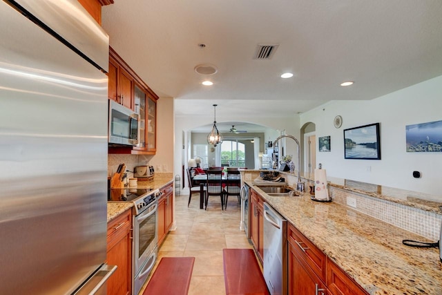 146 Palm Coast Resort Blvd Unit 501, Palm Coast, FL 32137 - kitchen with appliances with stainless steel finishes, arched walkways, brown cabinetry, glass insert cabinets, and recessed lighting
