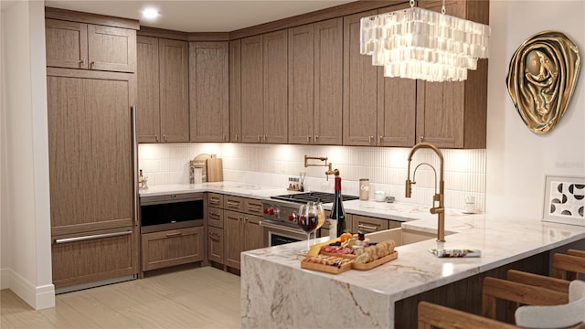 2360 Ocean Shore Blvd Unit 18, Ormond Beach, FL 32176 - kitchen featuring high end appliances, light stone countertops, a peninsula, tasteful backsplash, and a kitchen breakfast bar