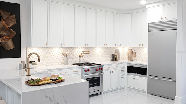 2360 Ocean Shore Blvd Unit 24, Ormond Beach, FL 32176 - kitchen with high quality appliances, light marble finish floors, a peninsula, white cabinetry, and recessed lighting