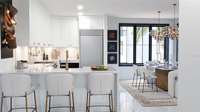2360 Ocean Shore Blvd Unit 9, Ormond Beach, FL 32176 - kitchen with built in refrigerator, a kitchen breakfast bar, backsplash, light countertops, and a peninsula