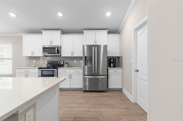 43 Lumber Jack Trl, Palm Coast, FL 32137 - kitchen featuring appliances with stainless steel finishes, ornamental molding, decorative backsplash, light wood finished floors, and white cabinetry