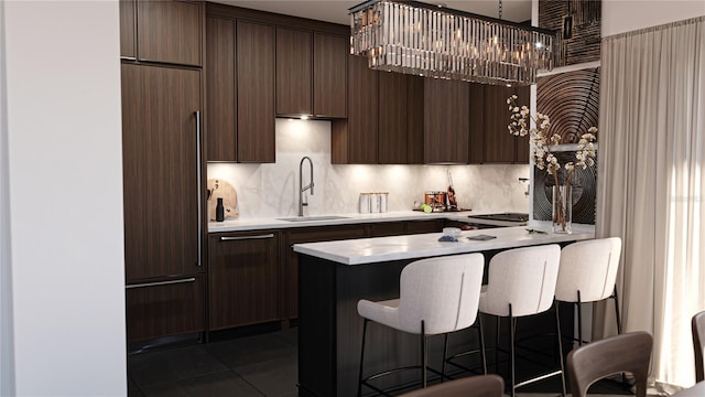2360 Ocean Shore Blvd Unit 11, Ormond Beach, FL 32176 - kitchen featuring paneled built in refrigerator, a breakfast bar, light countertops, dark brown cabinets, and a chandelier