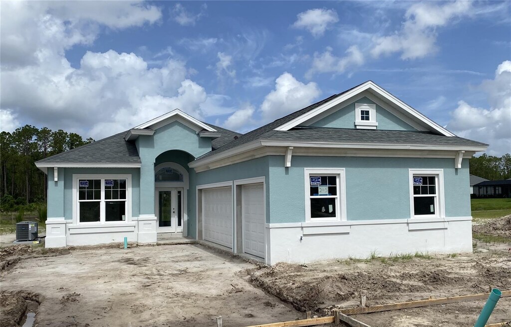 245 Hawthorn Ave, Palm Coast, FL 32164 - view of front of property featuring roof with shingles, an attached garage, concrete driveway, and stucco siding