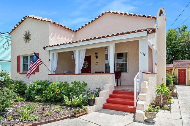 918 N Wild Olive Ave, Daytona Beach, FL 32118 - mediterranean / spanish-style home featuring covered porch, stucco siding, and a tiled roof